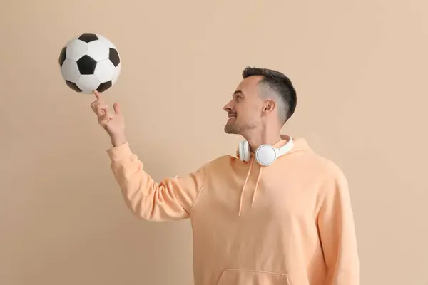 Glücklicher Junger Mann Mit Fußball Auf Beigem Hintergrund — Stockfoto