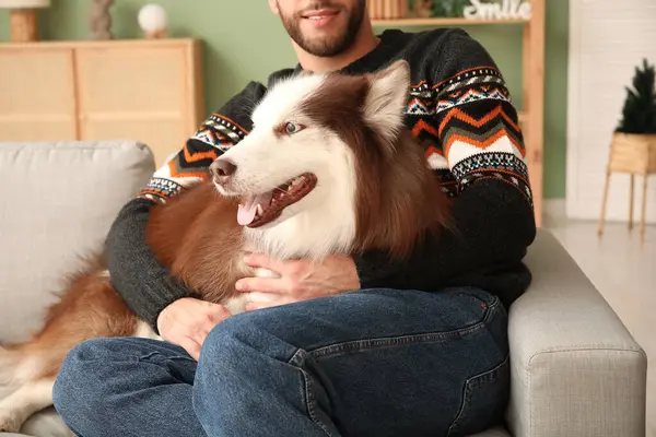 Man with cute Husky dog at home