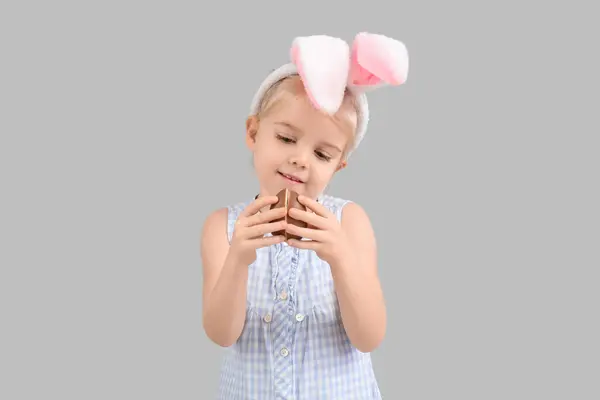 在兔子耳朵里可爱的小女孩 背景是灰色的巧克力蛋 复活节庆祝活动 — 图库照片