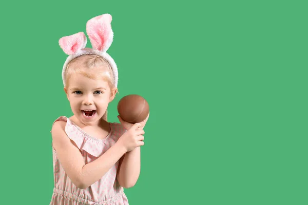在兔子耳朵里的快乐小女孩 绿色背景的巧克力蛋 复活节庆祝活动 — 图库照片