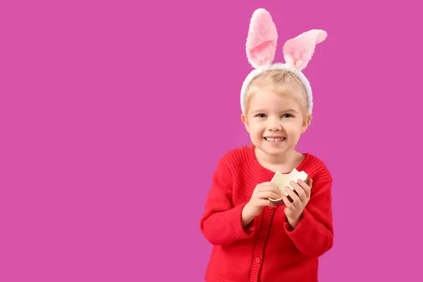 在兔子耳朵里的快乐小女孩 背景是紫色的巧克力蛋 复活节庆祝活动 — 图库照片