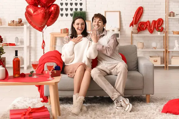 Sevgilisi olan genç adam nişan yüzüğünü evde gösteriyor. Sevgililer Günü kutlaması