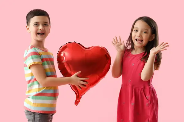 可爱的小男孩把心形气球送给粉红背景的女孩 情人节庆祝活动 — 图库照片