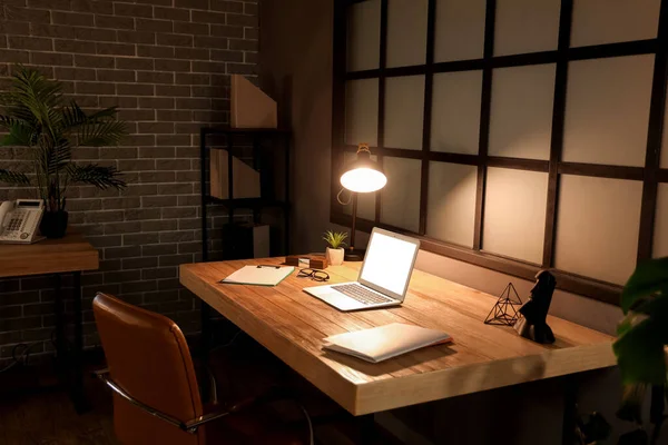 İşyeri ve gece lambasıyla karanlık ofisin içinde.