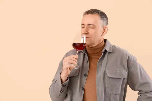 Schöner Reifer Mann Mit Einem Glas Wein Auf Beigem Hintergrund — Stockfoto