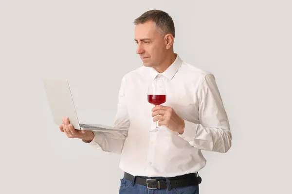Schöner Reifer Mann Mit Glas Wein Und Laptop Auf Weißem — Stockfoto