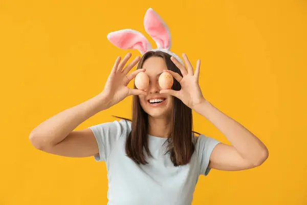 Vtipná Mladá Žena Králičí Uši Velikonoční Vajíčka Žlutém Pozadí — Stock fotografie