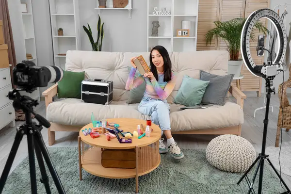 Kadın Asyalı güzellik blogcusu, evinde video kaydediyor.