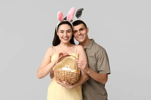 Šťastný Mladý Pár Velikonočním Košem Králičí Uši Šedém Pozadí — Stock fotografie