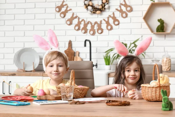 Schattige Kleine Kinderen Met Konijntjes Oren Schilderen Paaseieren Thuis — Stockfoto