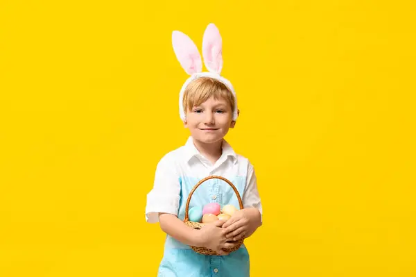Schattig Jongetje Konijnenoren Met Mand Van Paaseieren Gele Achtergrond — Stockfoto