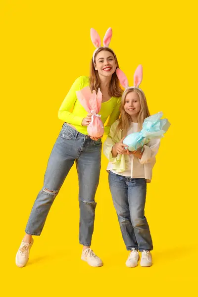 노란색 배경에 부활절 귀여운 소녀와 그녀의 어머니 — 스톡 사진