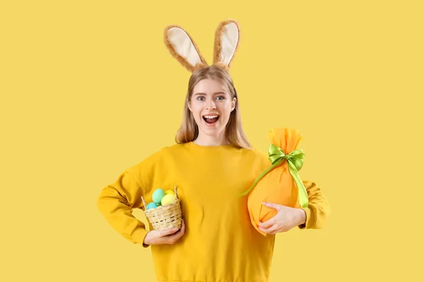 Młoda Kobieta Króliczych Uszach Jajkami Wielkanocnymi Żółtym Tle — Zdjęcie stockowe