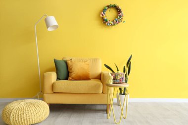 Paskalya çelengi, sarı koltuk ve lambalı oturma odası.