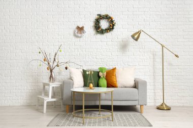 Paskalya çelenkleri ve kanepesi olan bir oturma odası.