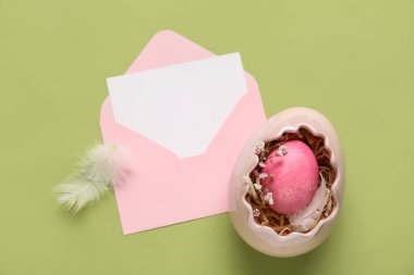 Yeşil arka planda boş kart, yumurta ve tüylü kompozisyon. Paskalya kutlaması