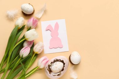 Tebrik kartı, lale ve bej arkaplanlı yumurta kompozisyonu. Paskalya kutlaması