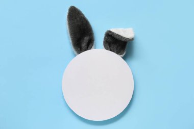 Yaratıcı kompozisyon. Mavi arka planda tavşan kulağı var. Paskalya kutlaması