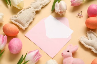 Beyaz kartlı kompozisyon, laleler ve bej arka planda Paskalya yumurtaları.