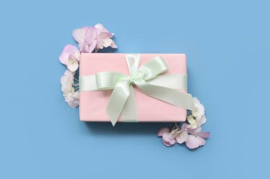 Mavi arka planda hediye kutusu ve ortanca çiçekleri. Uluslararası Kadınlar Günü