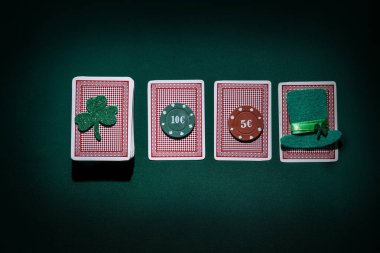 Poker fişleri, leprikon şapka ve koyu yeşil arka planda şanslı yonca. Aziz Patrick Günü kutlaması