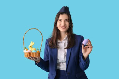 Mavi arka planda Paskalya yumurtaları olan güzel hostes.