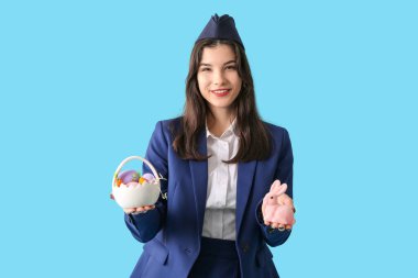 Paskalya tavşanı ve mavi arka planda yumurtaları olan güzel hostes.