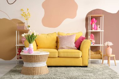 Masada kanepe, lale ve Paskalya yumurtaları olan bir oturma odası.