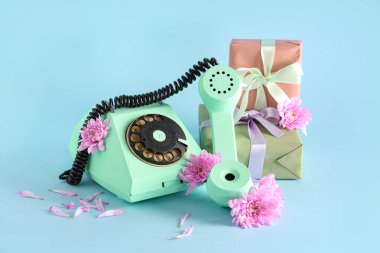 Retro telefon, güzel kasımpatı çiçekleri ve turkuaz arka planda hediye kutuları. Uluslararası Kadınlar Günü
