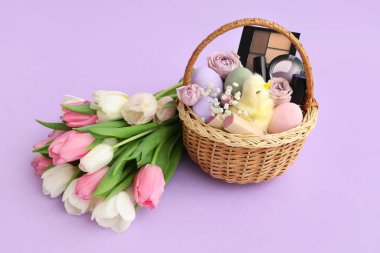 Dekoratif kozmetik ürünleri, Paskalya yumurtaları ve mor arka planda bir buket lale.