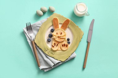 Turkuaz arka planda yabanmersinli komik Paskalya tavşanı krepleri.