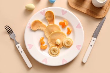 Sarı arka planda muzlu ve mandalinli komik Paskalya tavşanı krepleri.