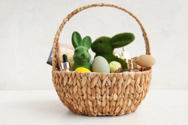 Süslü kozmetik sepetleri, beyaz arka planda Paskalya yumurtaları ve tavşanları.