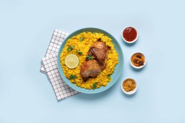 Mavi arka planda baharatlı geleneksel tavuk biryani kasesi.