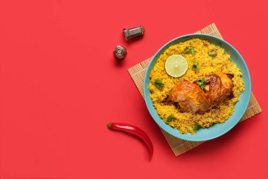 Kırmızı arka planda bir kase geleneksel tavuk biryani.
