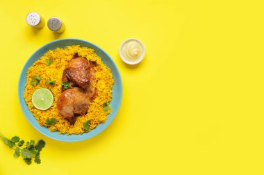 Sarı arka planda geleneksel tavuk biryani tabağı.