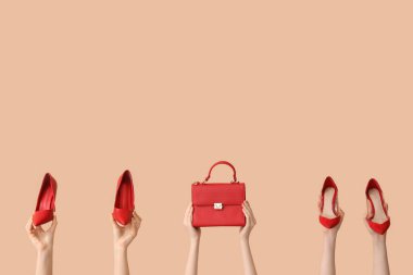 Kırmızı topuklu ve bej arka planda çantası olan kadınlar