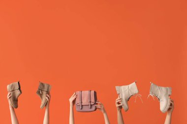 Şık çizmeleri ve turuncu arka planı olan kadınlar.