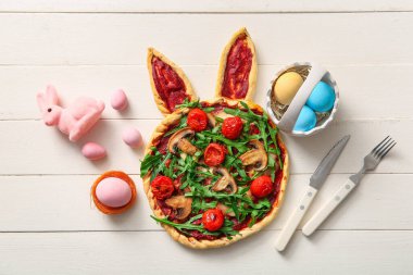 Lezzetli pizzalı kompozisyon ve beyaz ahşap arka planda Paskalya yumurtası.