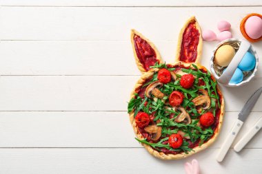 Lezzetli pizzalı kompozisyon ve beyaz ahşap arka planda Paskalya yumurtası.