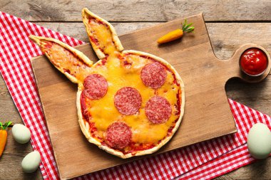 Ahşap arka planda lezzetli pizza ve yumurta kompozisyonu. Paskalya kutlaması