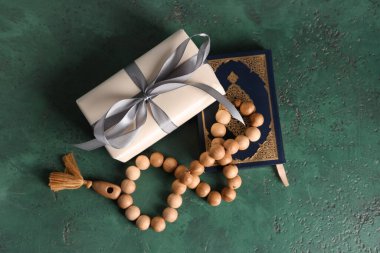 Yeşil grunge arkaplan üzerine Kur 'an ve Ramazan için tespih içeren hediye kutusu