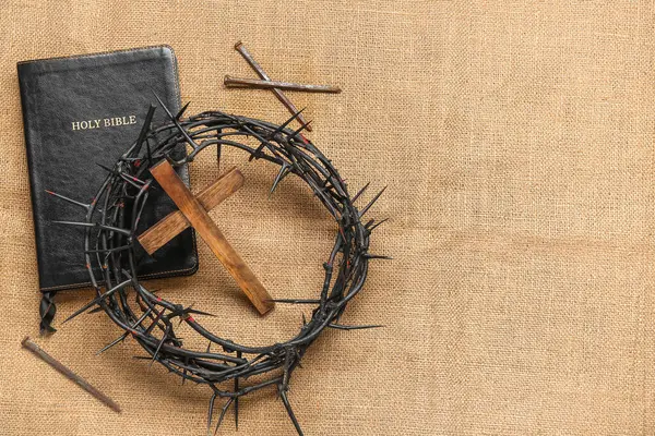 生地の背景に木製の十字架 聖書と爪が付いているソーンの冠 — ストック写真
