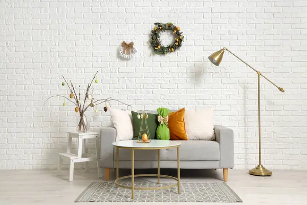 Paskalya çelenkleri ve kanepesi olan bir oturma odası.