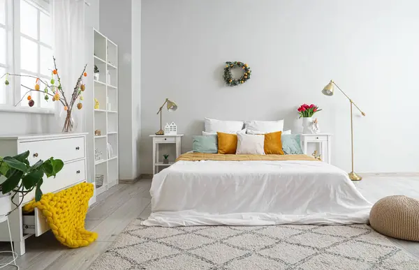 Paskalya çelengi ve masalarla aydınlık yatak odasının içinde.