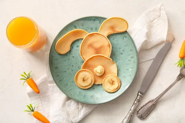 Beyaz fayanslı portakal suyu dolu komik Paskalya tavşanı krepleri.