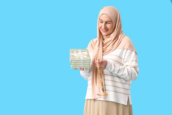 Starší Muslimská Žena Dárkovou Krabičkou Modlící Korálky Modrém Pozadí Ramadánská — Stock fotografie