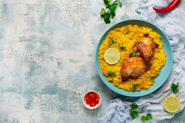 Mavi arka planda geleneksel tavuk biryani kasesi.