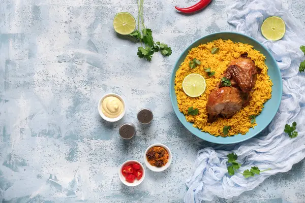 Mavi arka planda baharatlı geleneksel tavuk biryani kasesi.