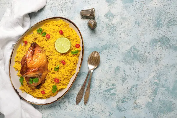 Mavi arka planda geleneksel tavuk biryani tabağı